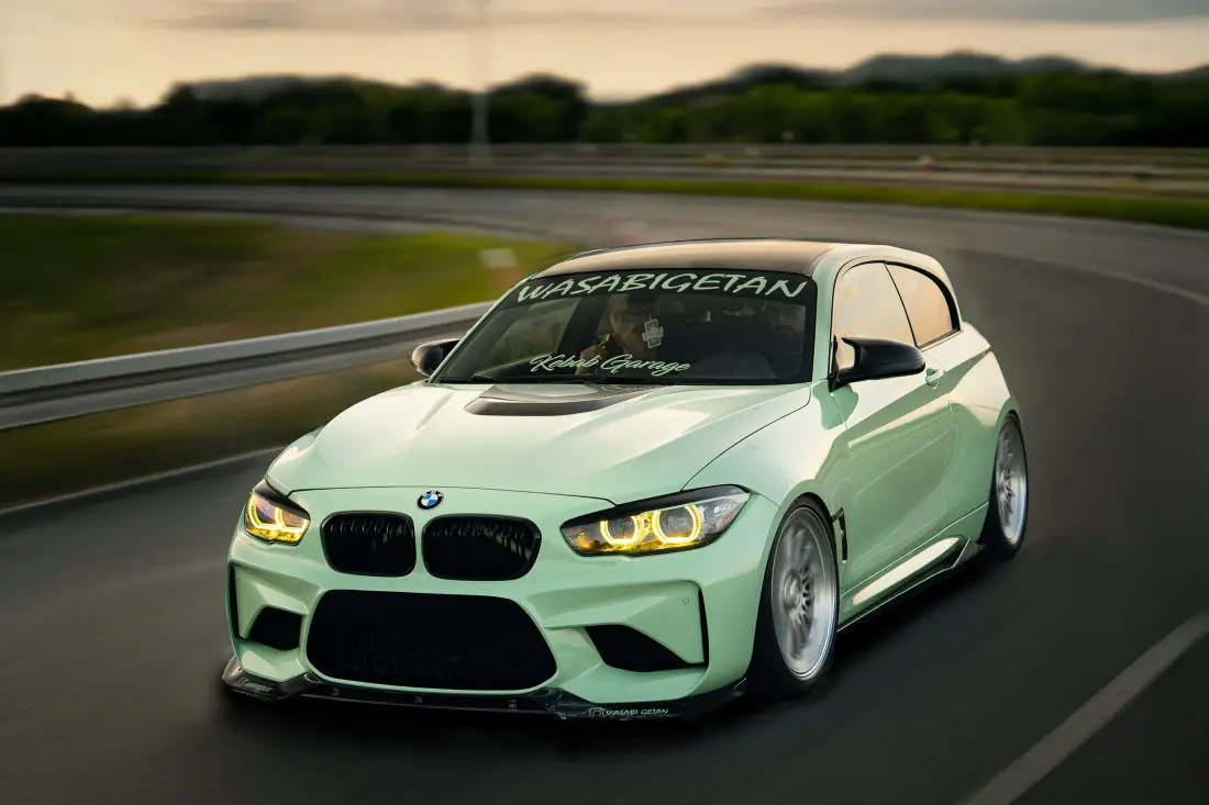 Mintgrüner BMW 1er in Fahrt auf einer Rennstrecke