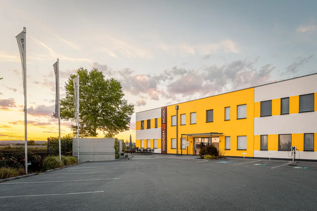 Wagram@Work office building in Grafenwörth in the evening light, flags and car park in front