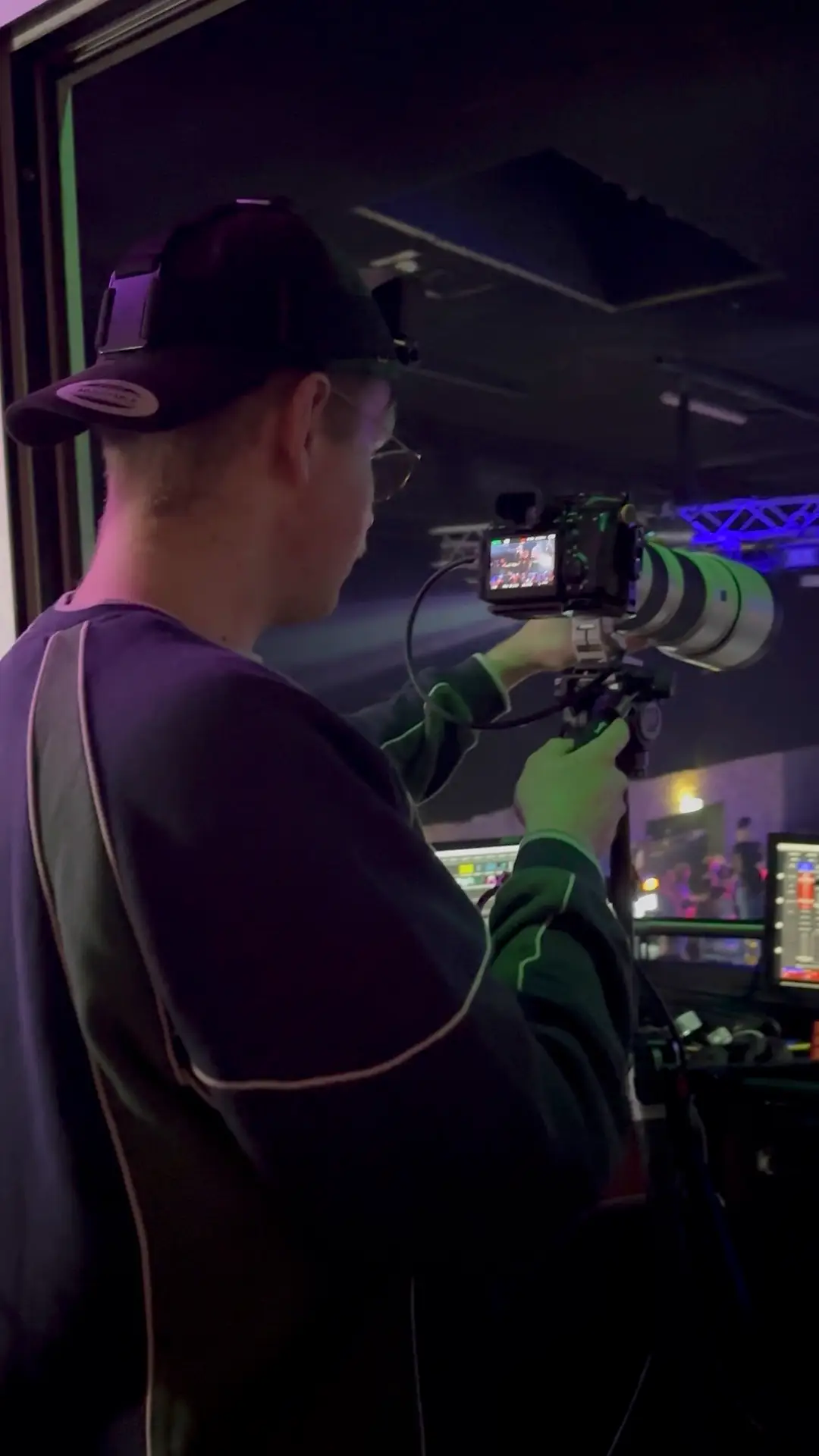 Camera operator in a cap filming the show from the stage with a gimbal