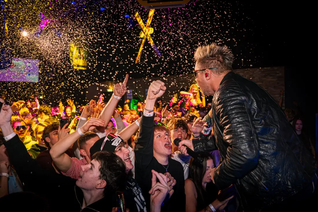 Performer in front of a cheering audience in a shower of confetti