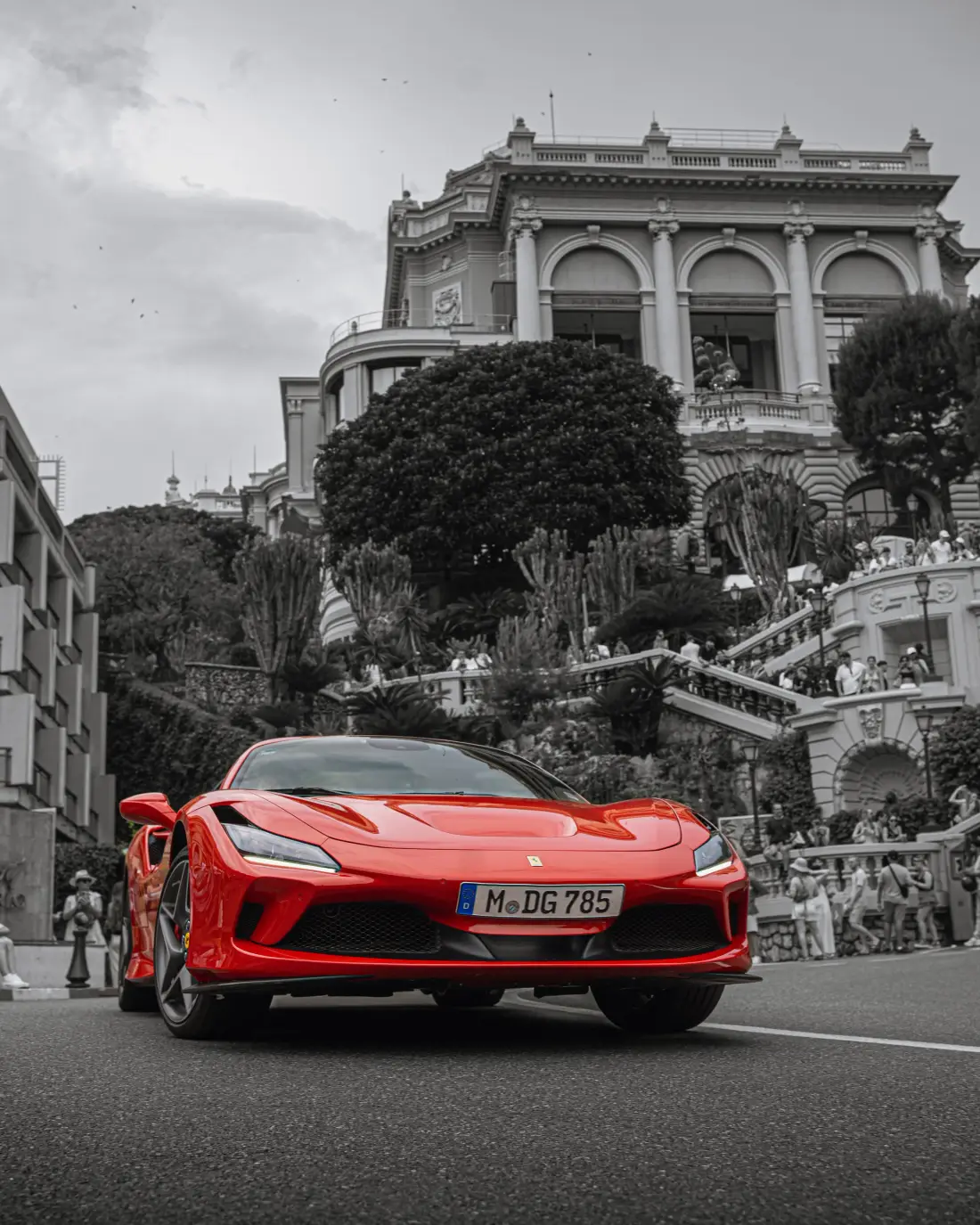 Roter Ferrari vor einem Prachtbau, der Hintergrund ist schwarz-weiß