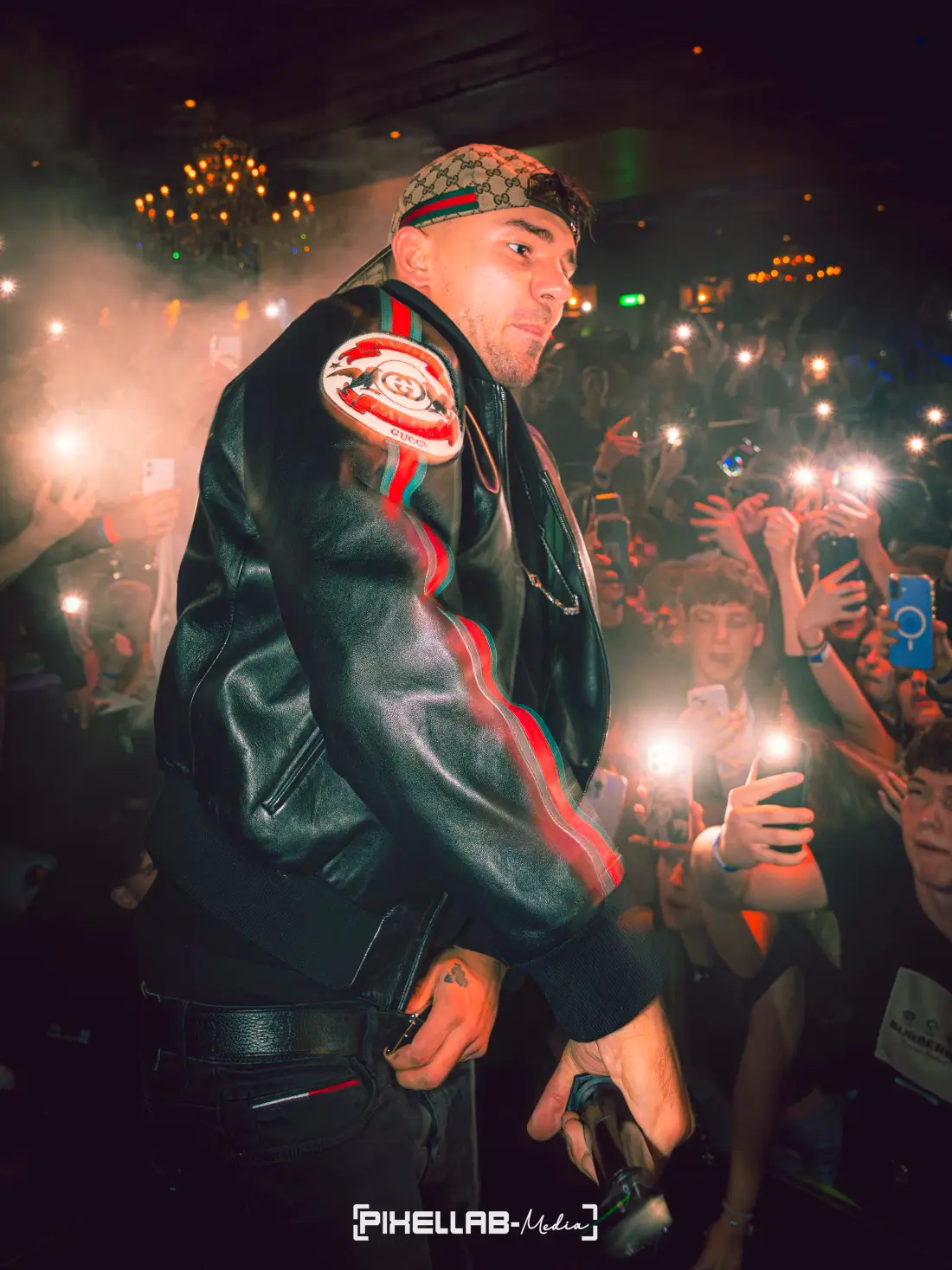 Performer in the crowd, fans holding up phone lights