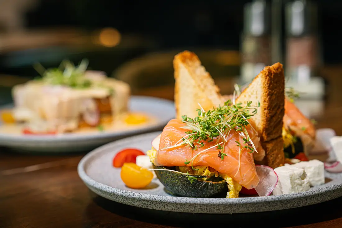 Plated dish with salmon, toast and herbs