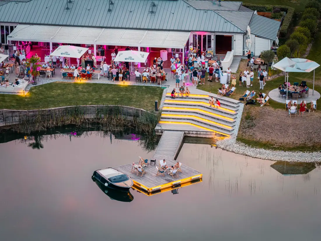 Aerial view of a lakeside event with terrace and jetty