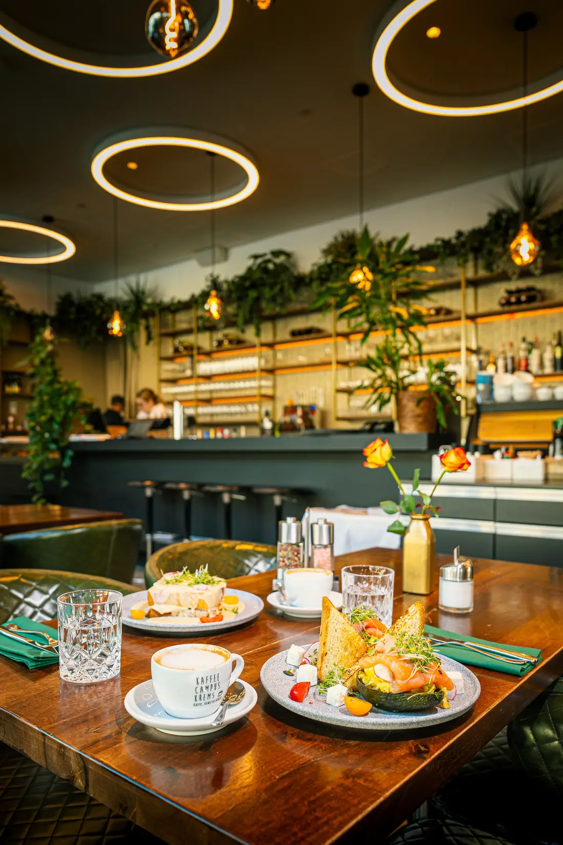 Gedeckter Tisch mit Frühstücksgerichten in einem Lokal mit Ringleuchten