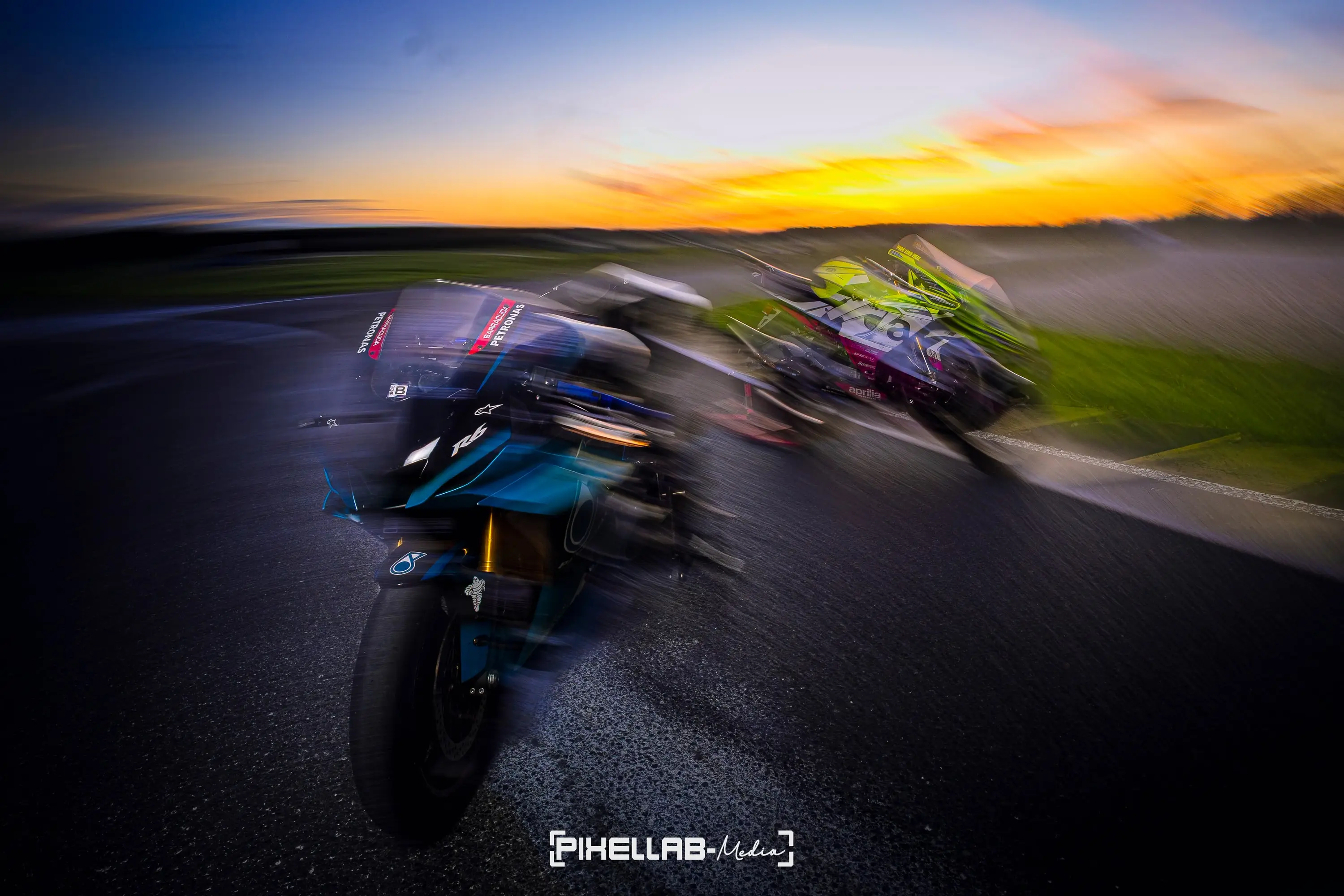 Two racing motorbikes with motion blur at dusk