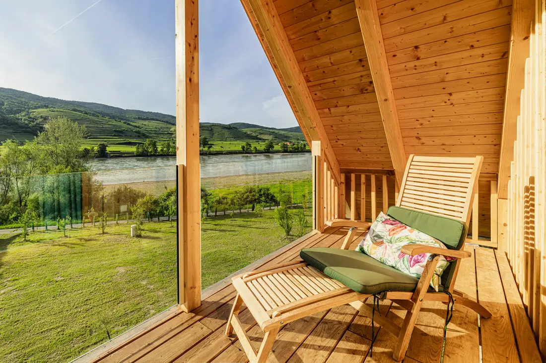 Überdachte Holzterrasse mit Liegestuhl, Blick auf die Donau und Weinterrassen
