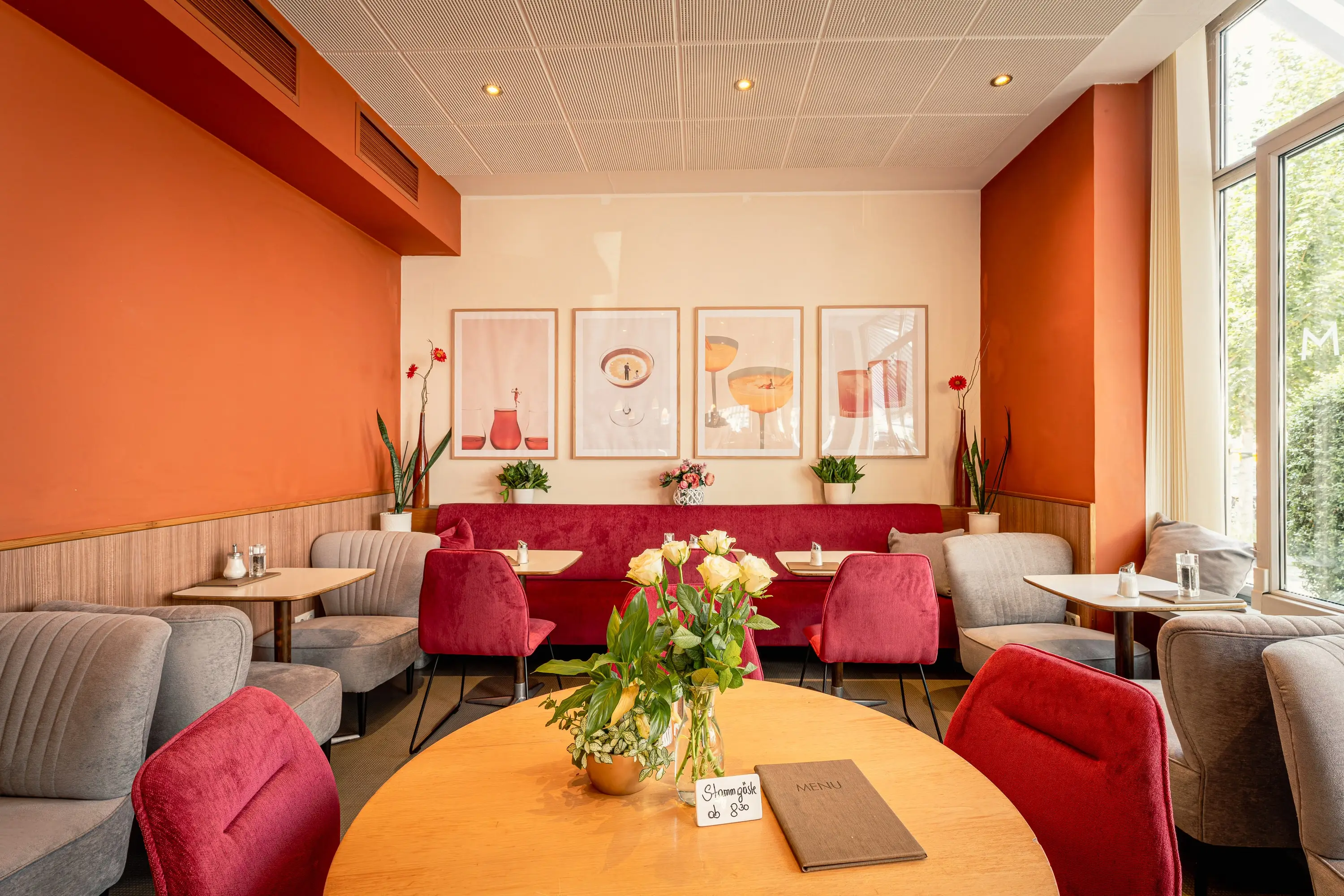 Café in Krems with a red bench, upholstered armchairs and framed pictures on the wall