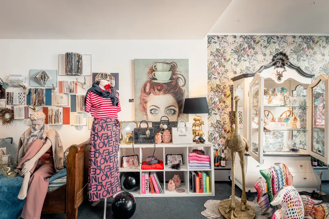 Boutique in Krems mit Schaufensterpuppen, Taschen und einem Porträtgemälde an der Wand