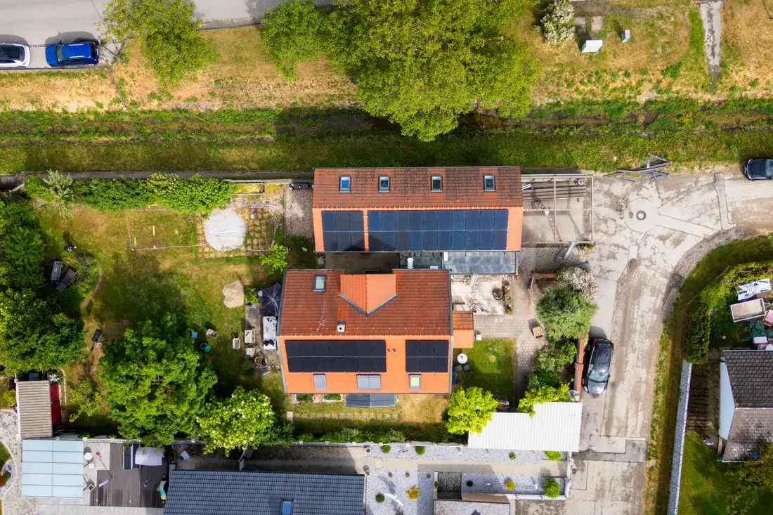 Senkrechte Luftaufnahme von Wohnhäusern mit Solaranlagen und Gärten