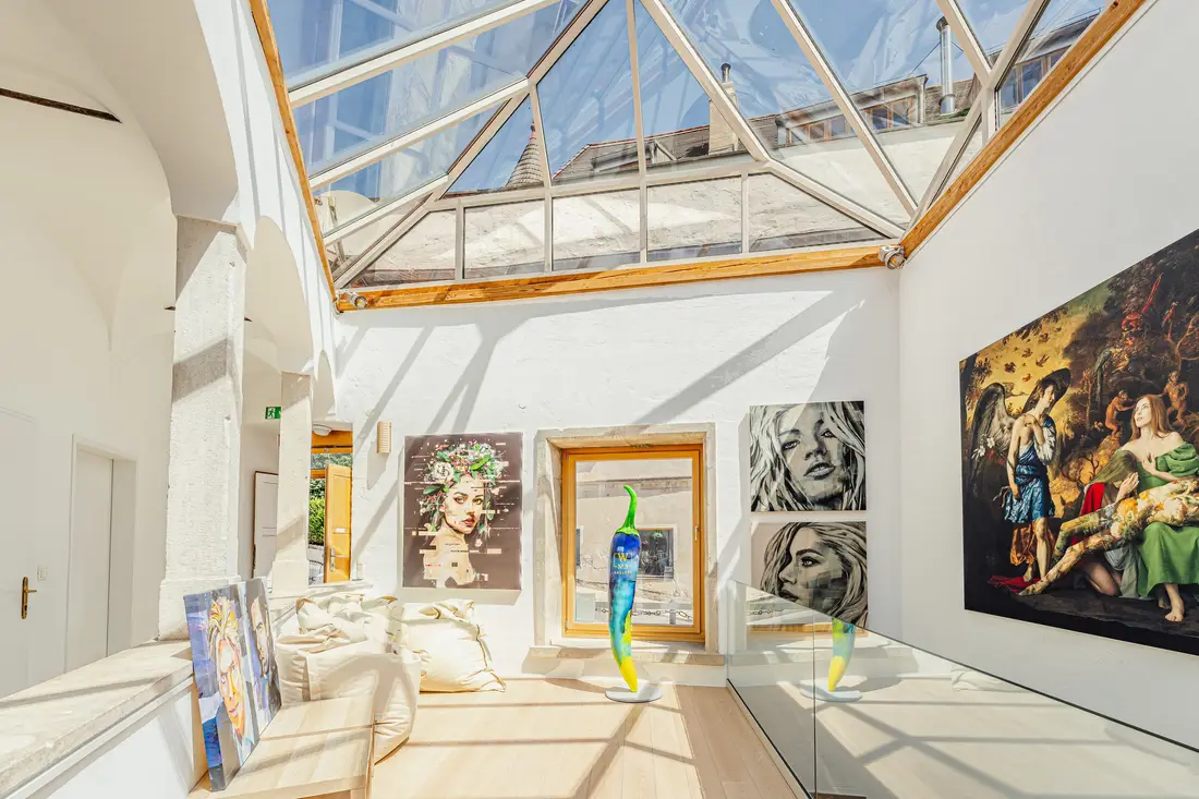 Heller Galerieraum mit Glasdach und großformatigen Gemälden