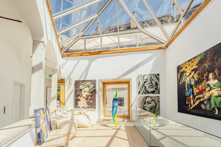 Gallery with a glass roof and paintings on white walls